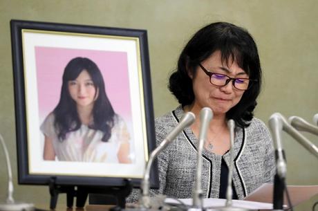 Mẹ của Matsuri Takahashi khóc trước di ảnh con gái. Ảnh: Japan Times